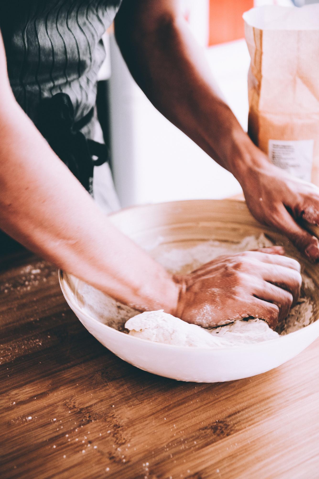 Hands kneading dough in workshop